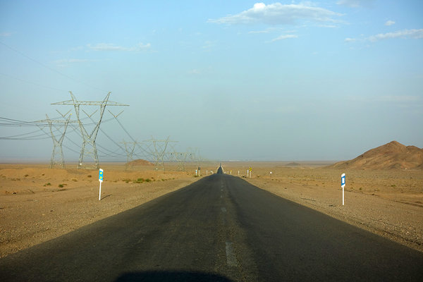 bis zum Horizont geradeaus. Langsam wieder in Richtung Zivilisation: die Stromversorgung ist für eine Mine mitten in Wüste und eine nahe Aluminiumfabrik. Iran.