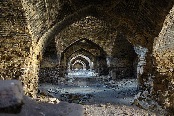 Khargushi Caravanseray. Typische Innenansicht einer solchen Raststation. Oben an den kuppelförmigen Abteilungen sind Öffnungen für Lichteinlass und Belüftung. So ist es innen kühler als draußen und man hat doch Licht. In den nischen rechts und links haben die Reisenden genächtigt und/oder es waren kleine Verkaufsstände der reisenden Händler. Iran.